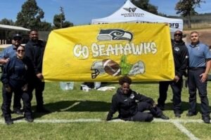 an officer sitting in front of a yellow banner