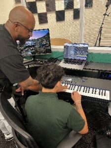 Someone teaching someone to play keyboard