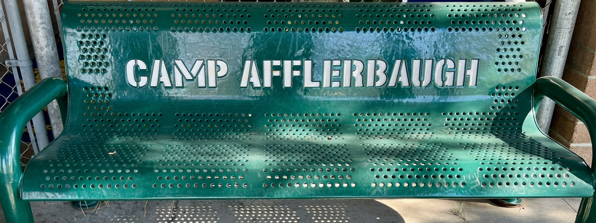 Green bench with Camp Afflerbaugh inscribed on it