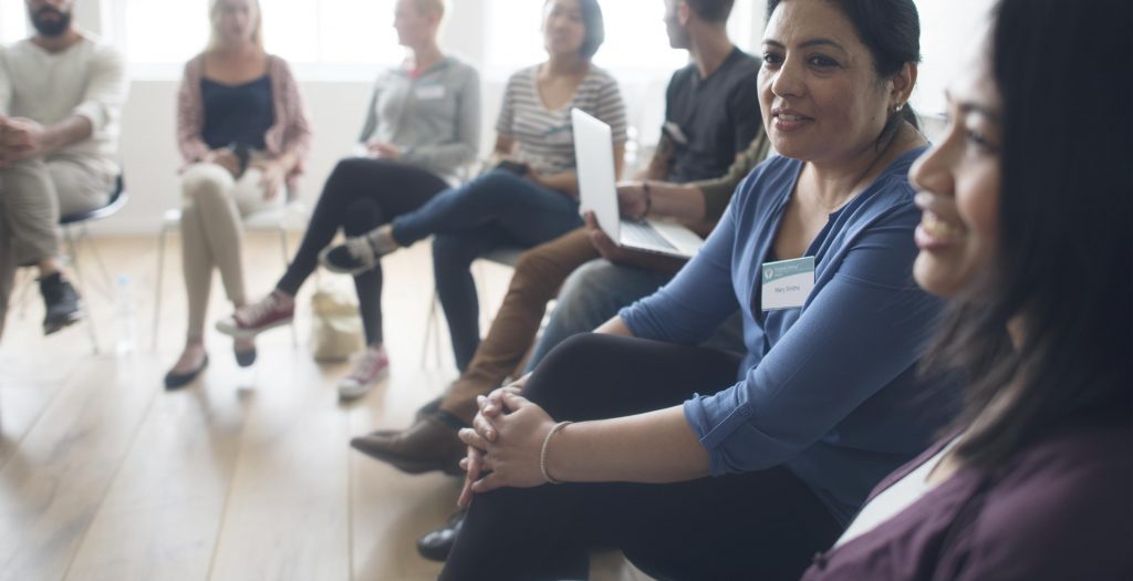 Two women talking in a meeting.